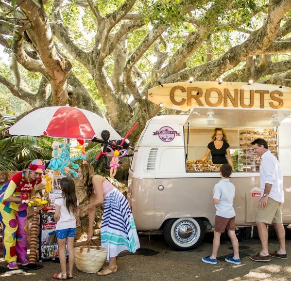 A group of people standing in front of a food truck during a sunshine coast day trip.