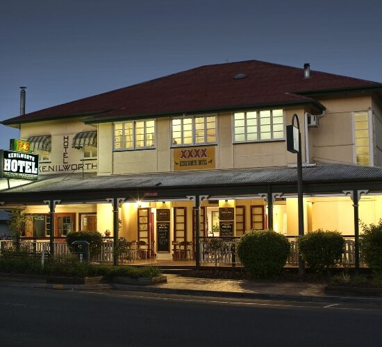 A hotel on the corner of a street at night, perfect for Sunshine Coast sightseeing.