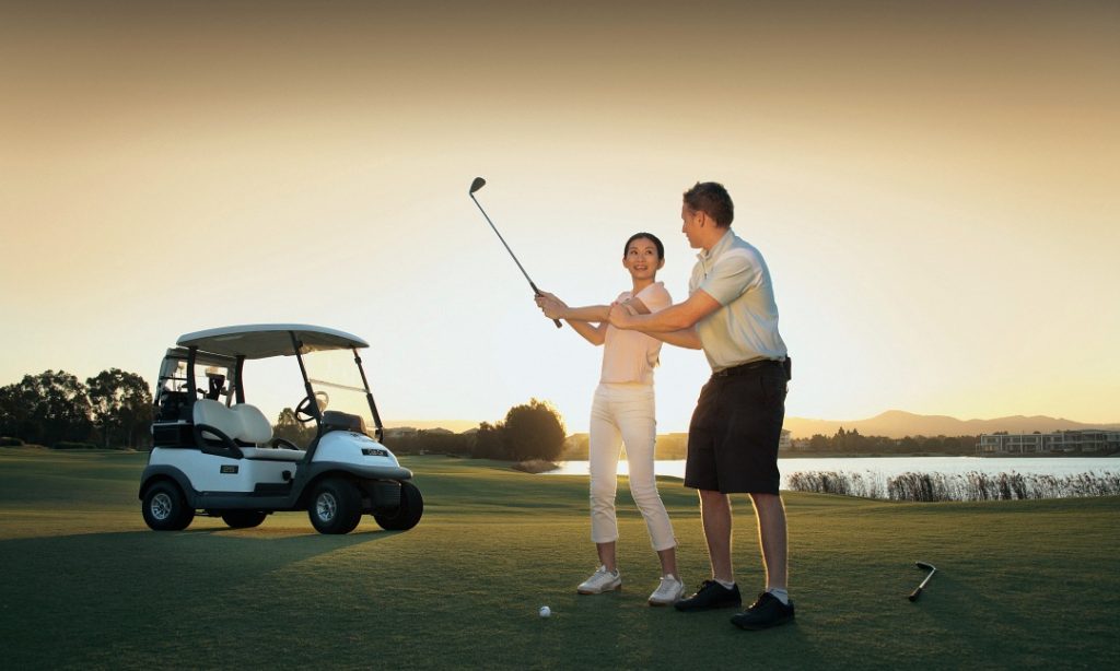 A man and woman enjoying a round of golf on a picturesque golf course.