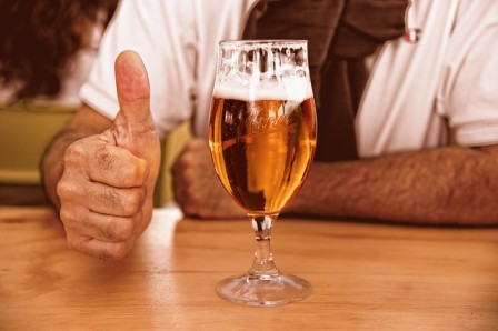 A man is holding a glass of beer while giving a thumbs up on one of the sunshine coast tours. Sunshine Coast Brewery Tour