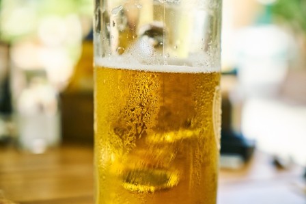 A glass of beer sitting on a wooden table during a sunshine coast sightseeing tour.