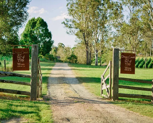 A gate leading to a dirt road on a farm, providing easy access for Maleny wine tours.