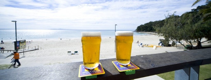 Two glasses of beer on a balcony overlooking a beach during a sunshine coast wine tour. sunshine coast brewery tours, sunshine coast brewery tour, brewery tours sunshine coast, breweries sunshine coast, sunshine coast beer tour, brewery tours sunshine coast