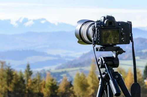 A DSLR camera on a tripod capturing the breathtaking mountains in the Sunshine Coast Hinterland.