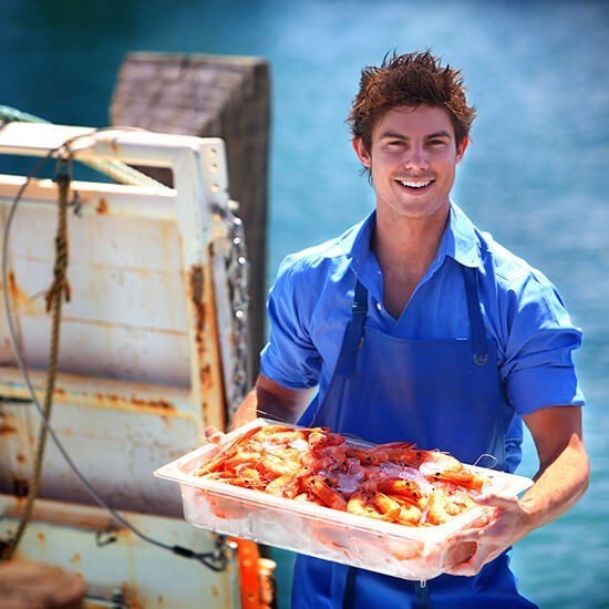A young man holding a tray of seafood during a sunshine coast sightseeing tour.